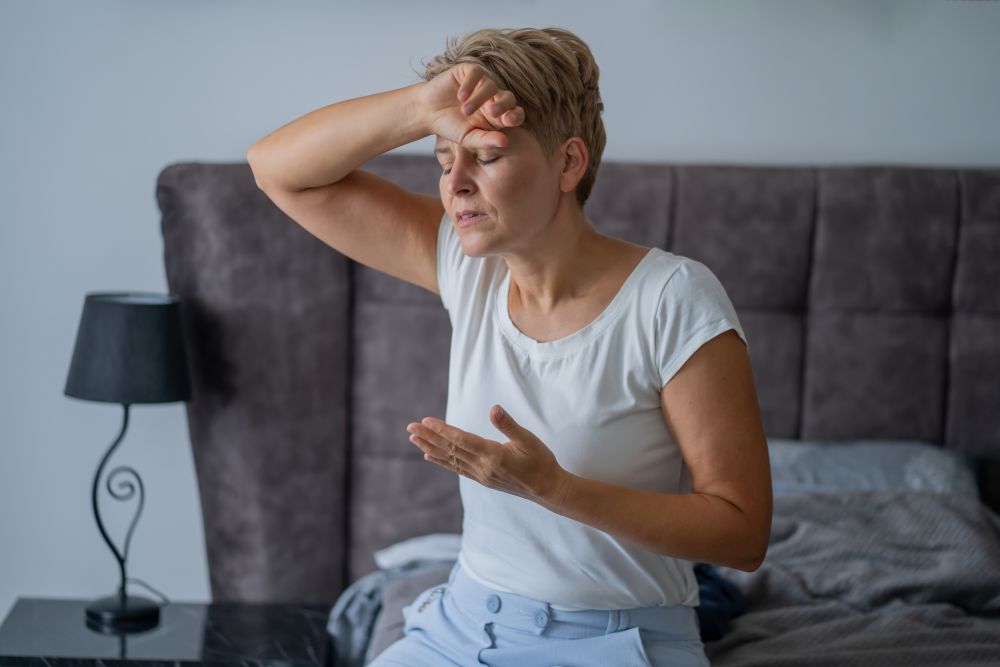 donna in menopausa a letto con sudorazione per vampate di calore